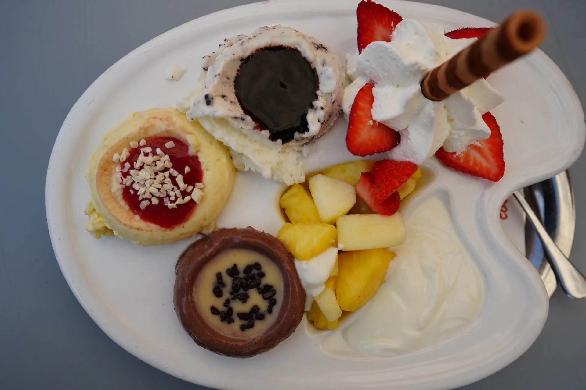 Eisbecher-Teller im Eiscafé San Remo – Kugeln, Früchte, Sahne und Waffelröllchen