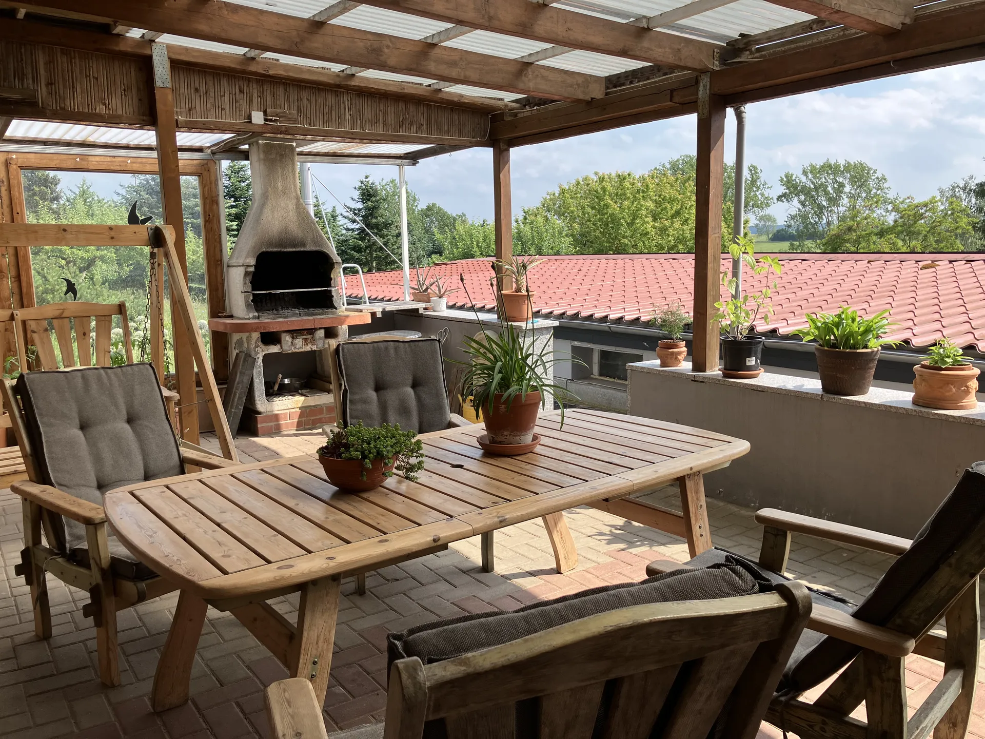 Überdachte Terrasse mit Grill und Sitzgelegenheiten