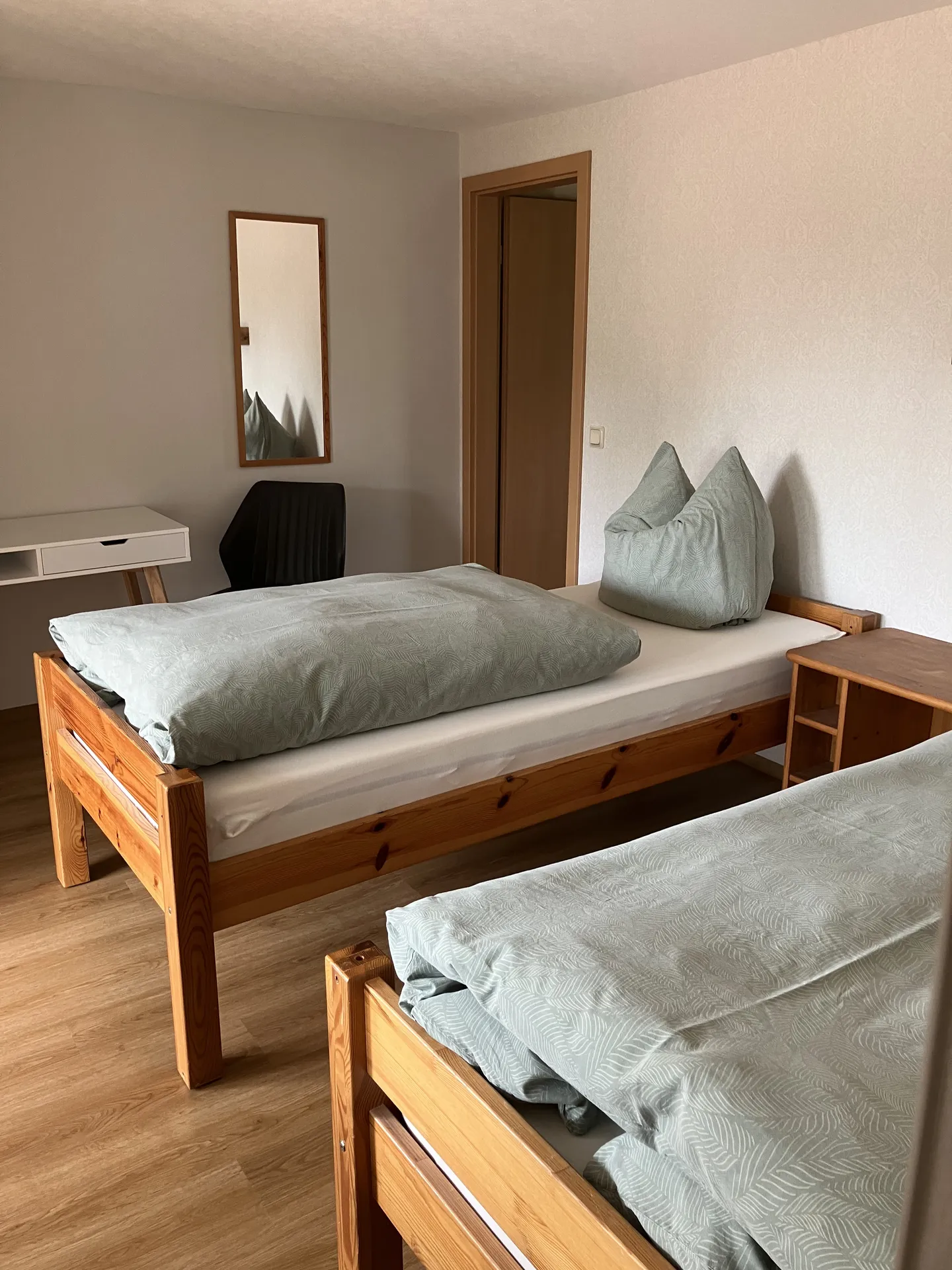 Schlafbereich mit Kiefernmöbeln und Spiegel