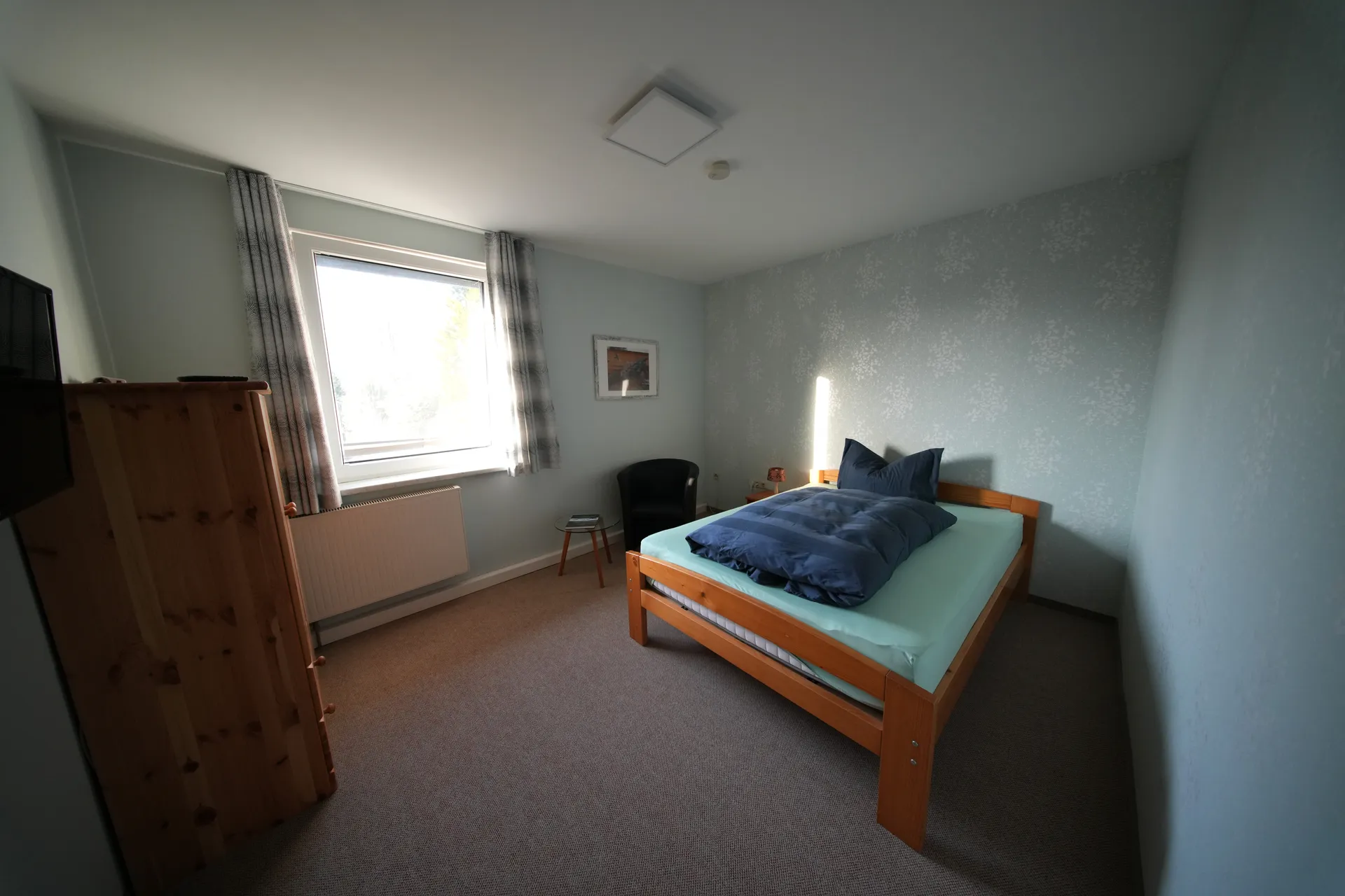 Einzelzimmer mit Einzelbett, Schrank und Fenster