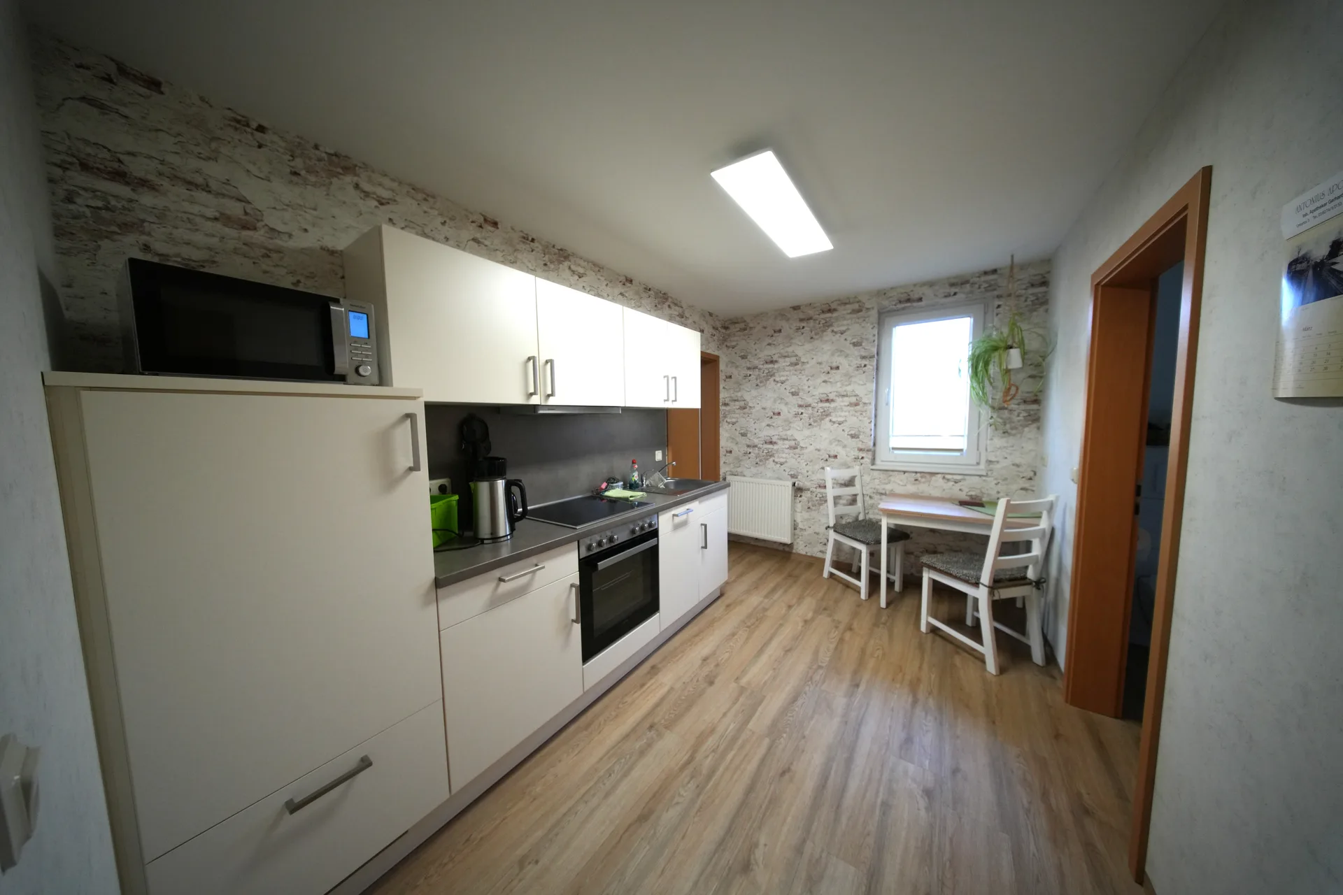 Emil's Kuhwiese – Kitchen with stone wallpaper, stove and dining area