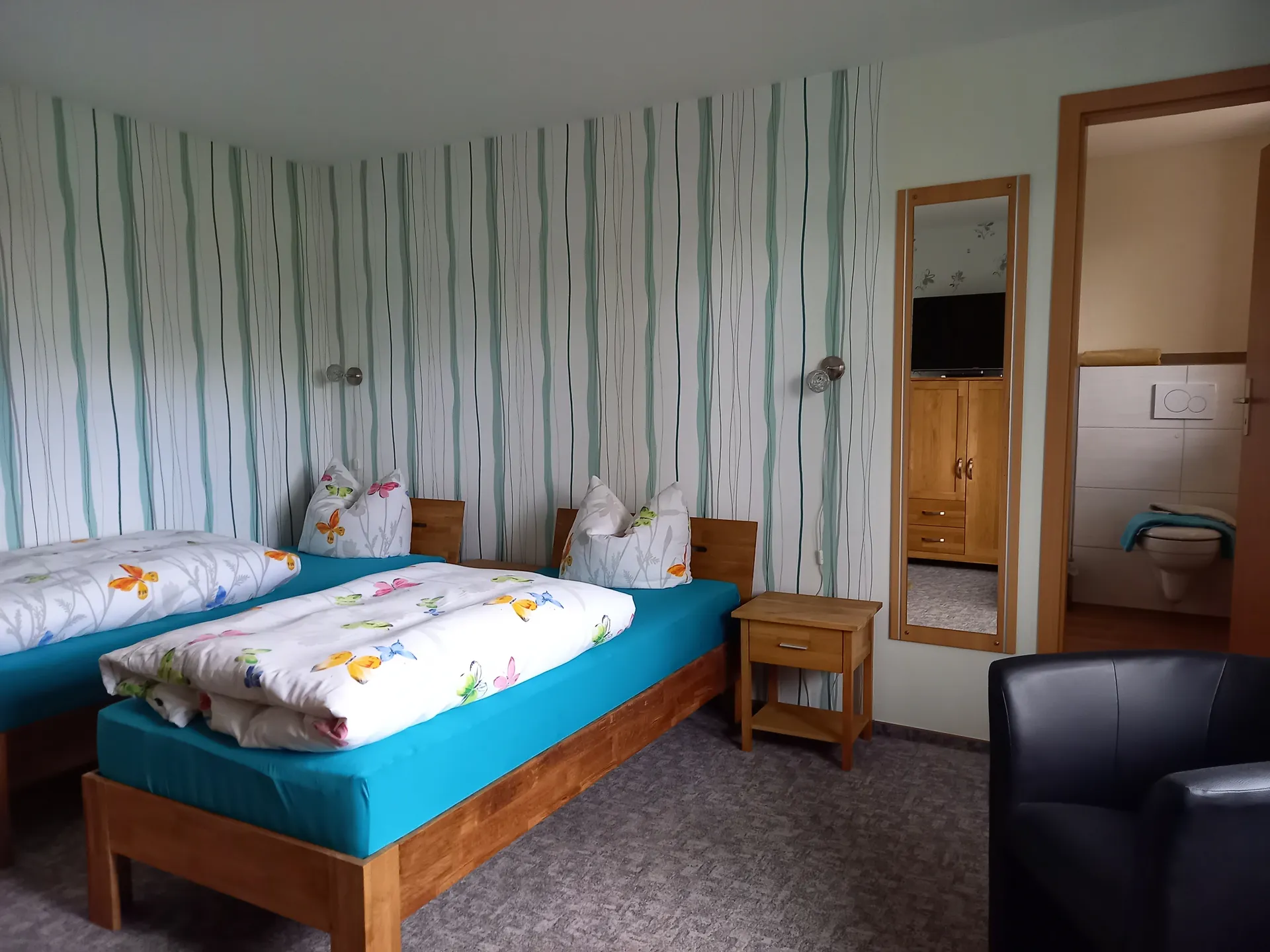 Doppelzimmer mit Einzelbetten und Blick ins Bad