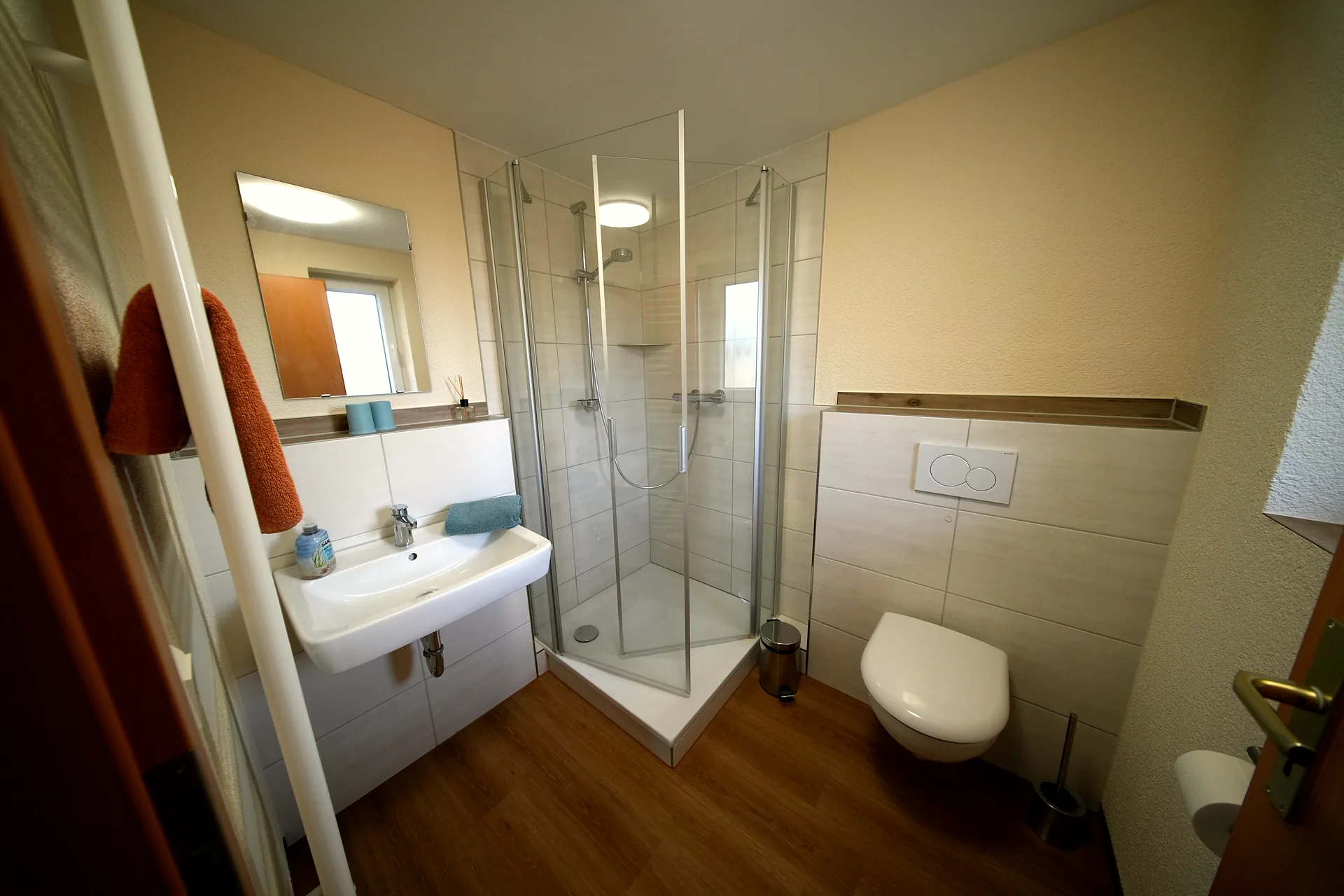 Bathroom with corner shower, washbasin and towel holder