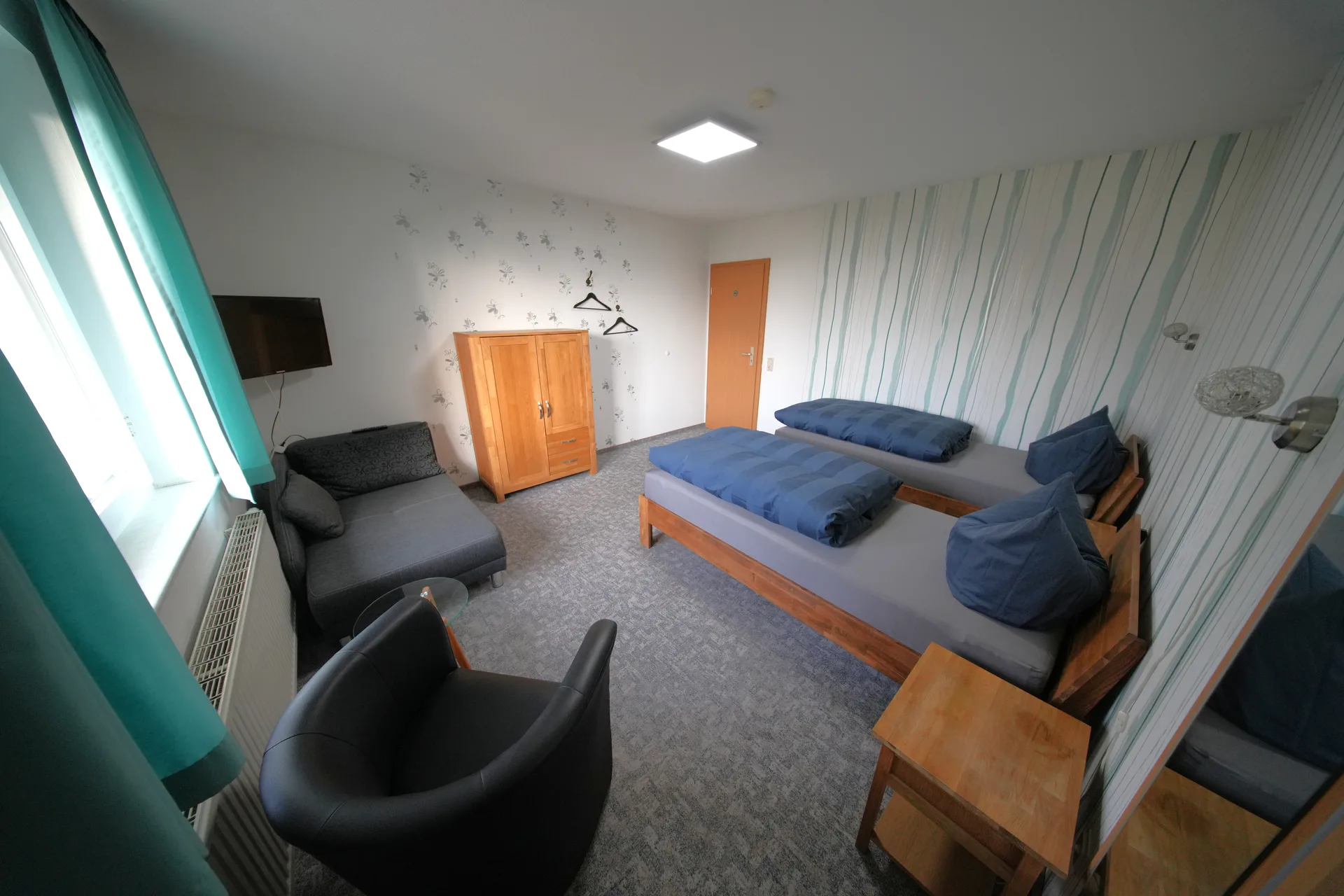 Rose Garden – Room overview with sofa, armchair and both single beds