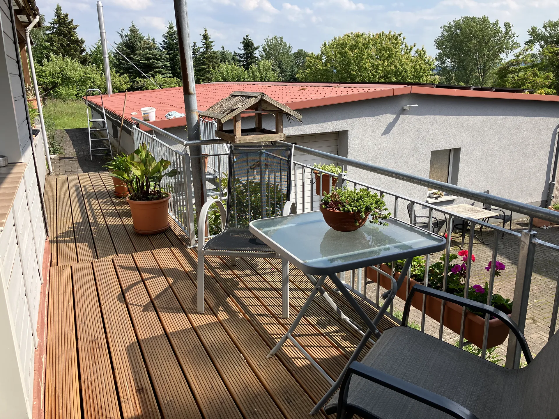 Balkon mit Vogelhaus und Gartenpanorama