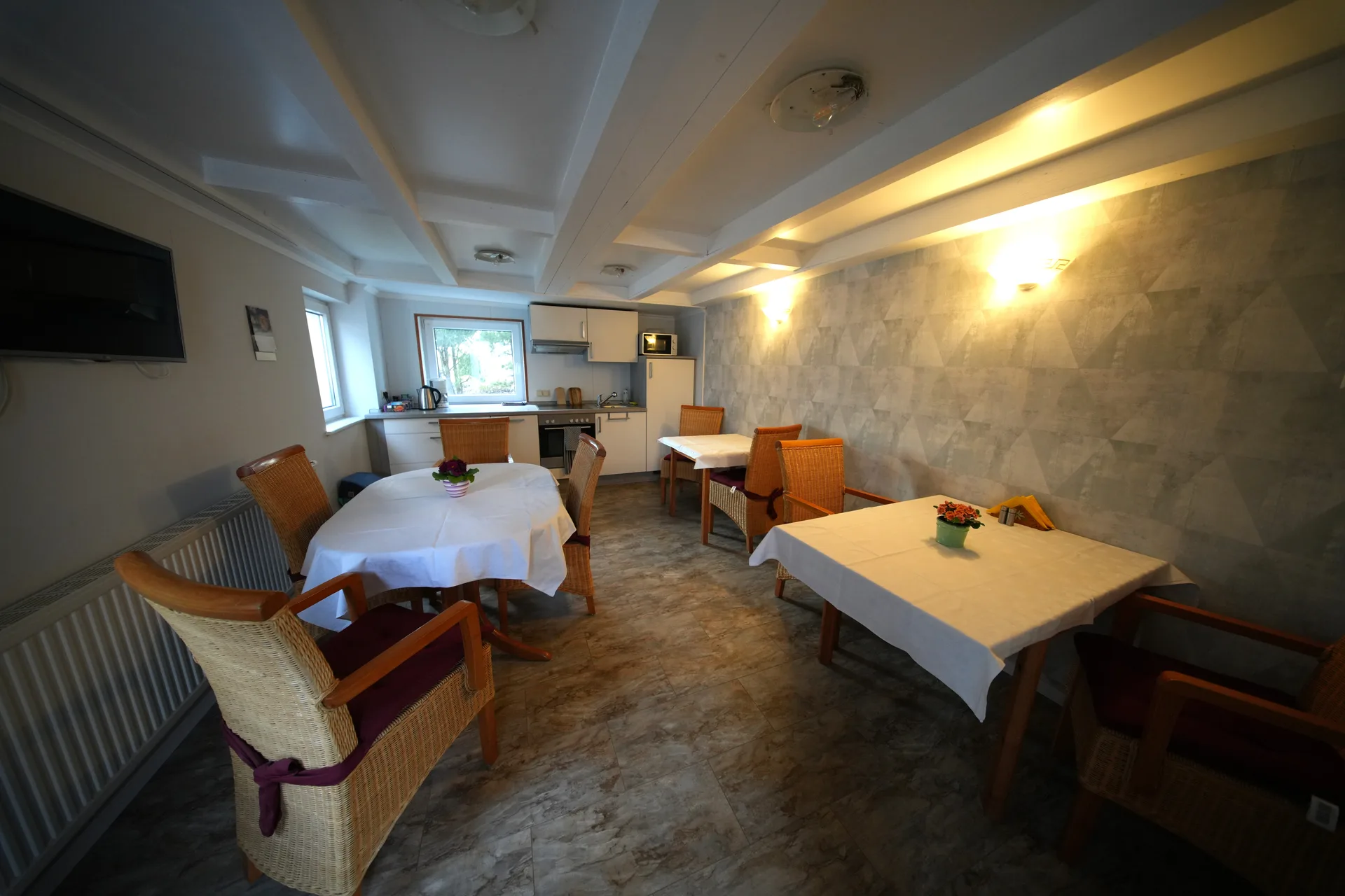 Gemeinschaftsküche mit Frühstückstischen und stimmungsvoller Beleuchtung