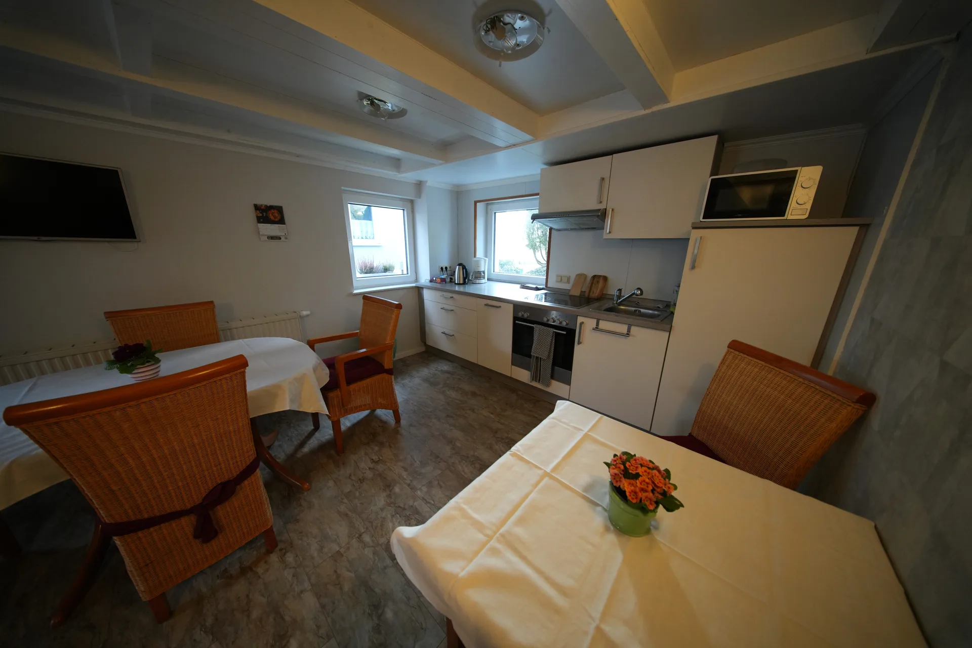 Shared kitchen with cooking area, dining space and fresh flowers
